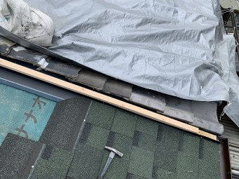 隣屋と取り合い部分の瓦を補修して、捨て板金を取り付けます。