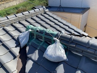 棟止まり部分のノシ瓦が崩れたのか、養生テープと土嚢で固定されています。