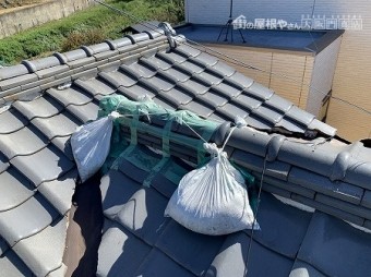 棟止まり部分のノシ瓦が崩れたのか、養生テープと土嚢で固定されています。