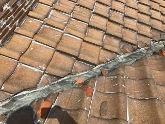 谷部の瓦下にコーキングが打たれ雨水を止めてしまいます。