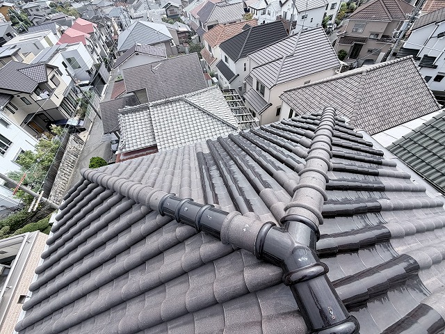 数年前に関西を襲った巨大台風の際、こちらのお客様宅も被災され、当時は部分的な補修工事を行ってしのいだそうです。しかし、近年の異常気象を目の当たりにし、「今後また大きな台風や地震が来たときに今のままで大丈夫だろうか」と不安が募ったとのこと。そこで、今後の安心のために「軽くて飛散しにくい（風で飛ばされにくい）屋根材に変えたい」というのが一番のご要望でした。さらに、「夏場に2階がものすごく暑くなるので、もし涼しくできる対策があるなら一緒にやりたい」という切実なお悩みもあわせてご相談いただきました。