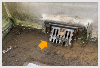 排水溝に泥が流れ込んでいる様子